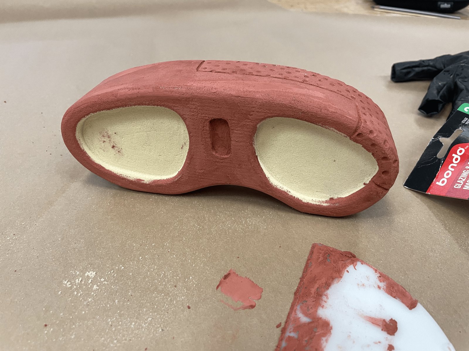 PU foam physical model of the speaker, painted red, in progress on a workbench